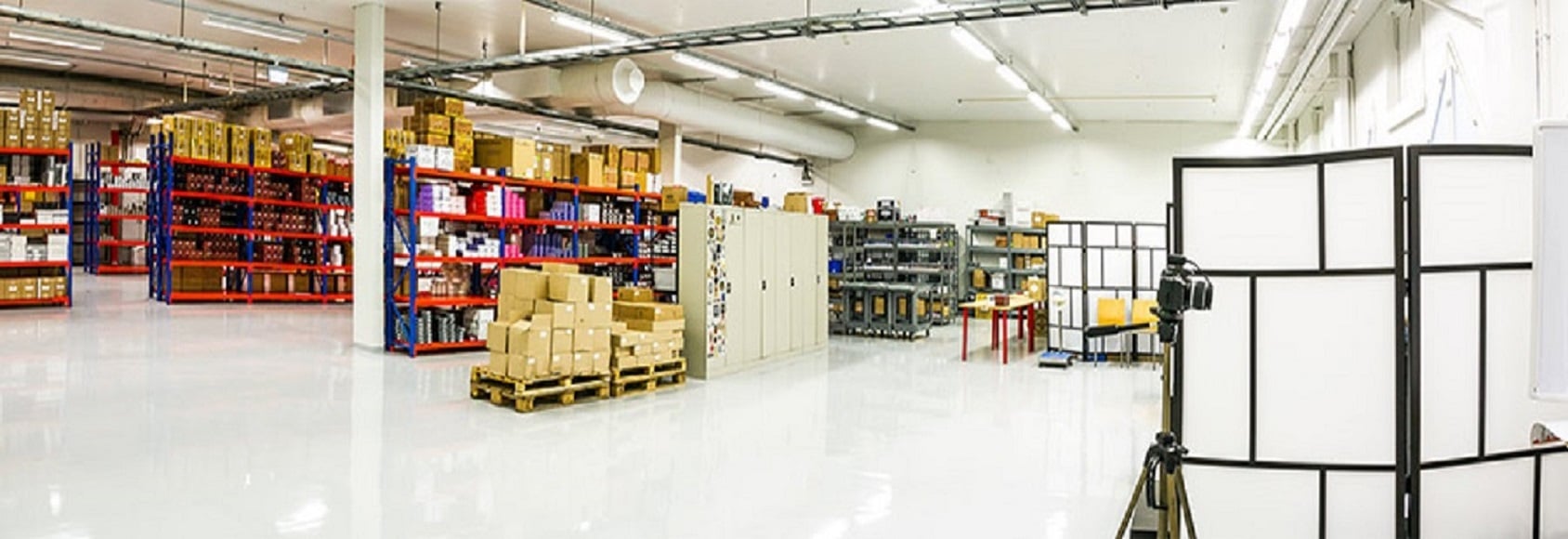 Kuva tuotantohallin sisältä, pahvilaatikoita hyllyissä.